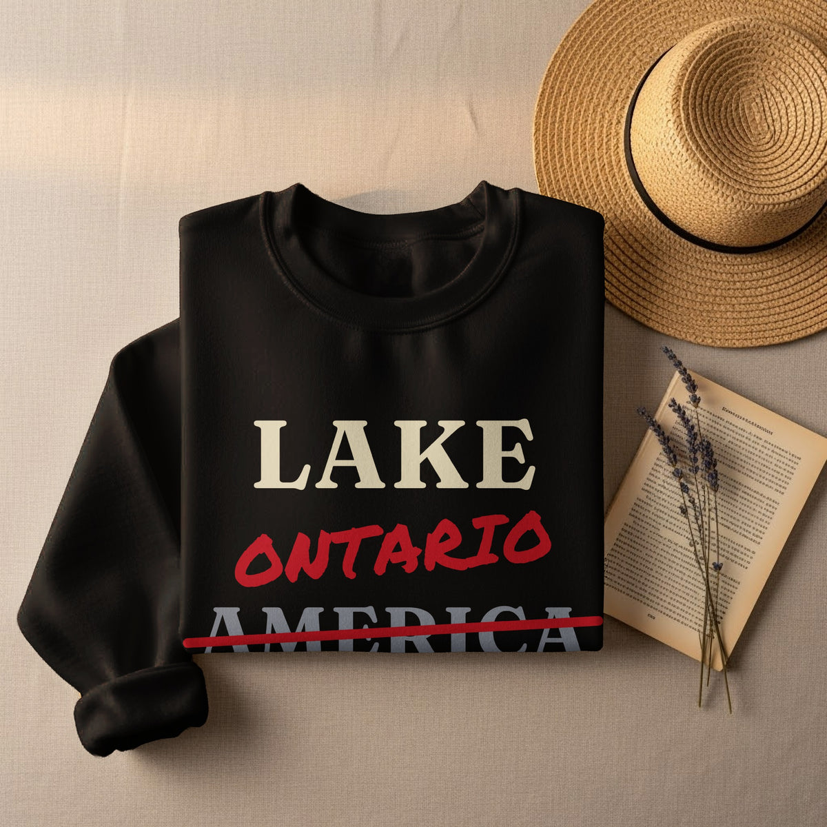 Black sweatshirt with "LAKE ONTARIO AMERICA" text, straw hat, and book.