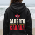 Black hoodie with "Alberta Is Canada" text and floral maple leaf design.