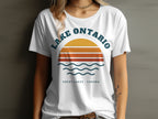 White t-shirt with "Lake Ontario Great Lakes Canada" text and sunset graphic.