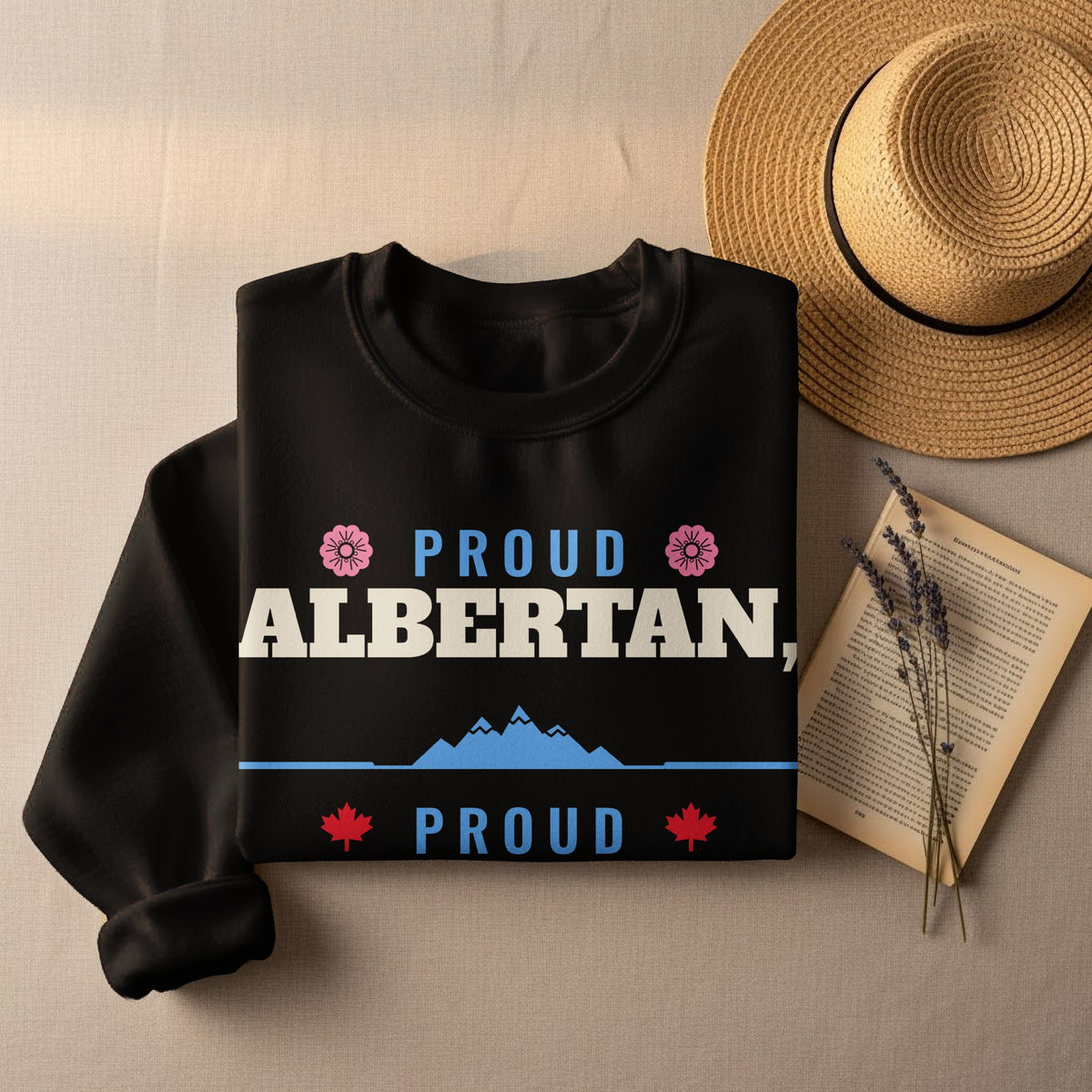Black sweatshirt with "Proud Albertan" text, mountains, and maple leaves.