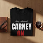 Black t-shirt with "keep calm and CARNEY ON" text, next to a notebook, glasses, and coffee.