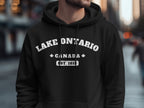 Black hoodie with white text "LAKE ONTARIO CANADA EST. 1614".
