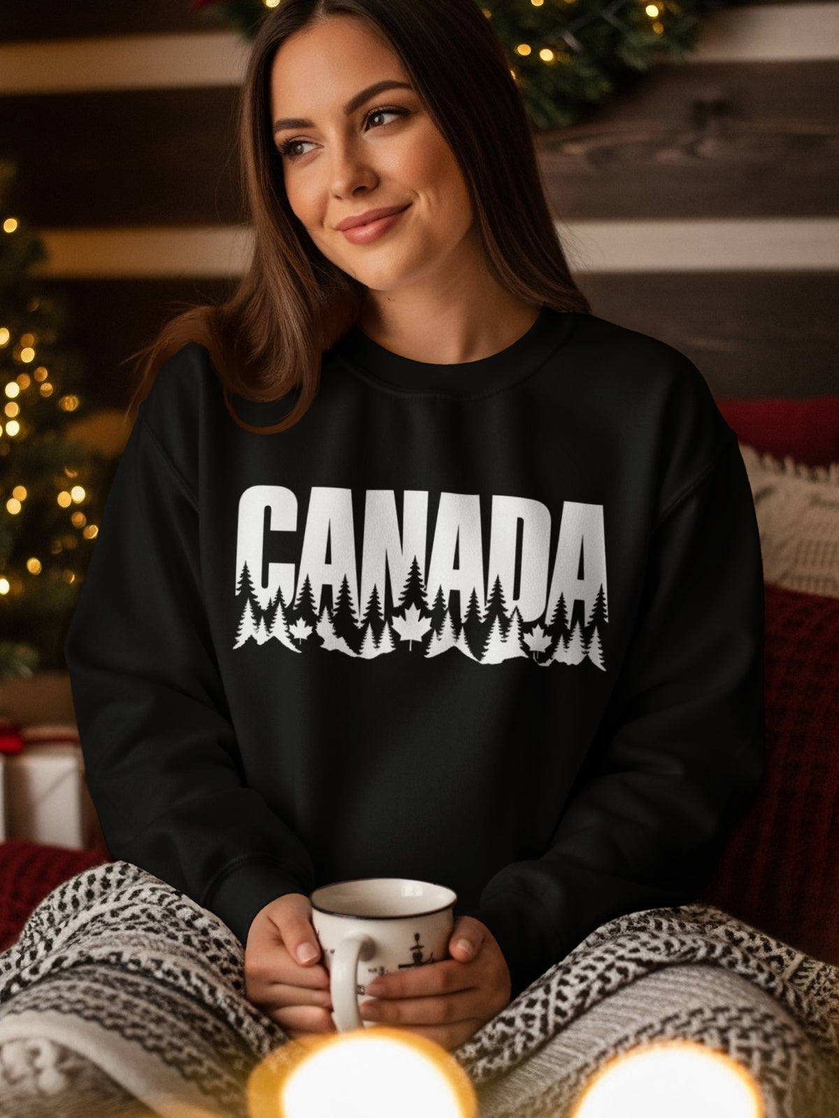 Black sweatshirt with white "CANADA" text, pine trees, and maple leaves.
