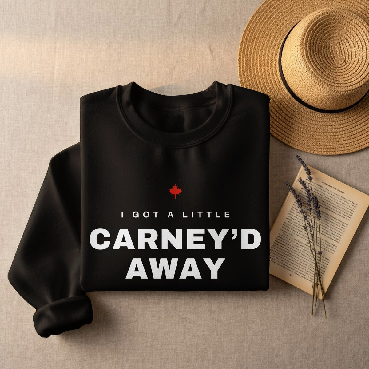 Black sweatshirt with white text that reads "I GOT A LITTLE CARNEY'D AWAY" and a red maple leaf.