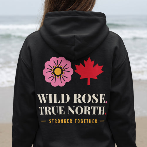 Black hoodie with pink wild rose, red maple leaf, and text "WILD ROSE. TRUE NORTH. STRONGER TOGETHER."
