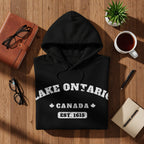 Black hoodie with Lake Ontario, Canada, Est. 1615 text and maple leaves.