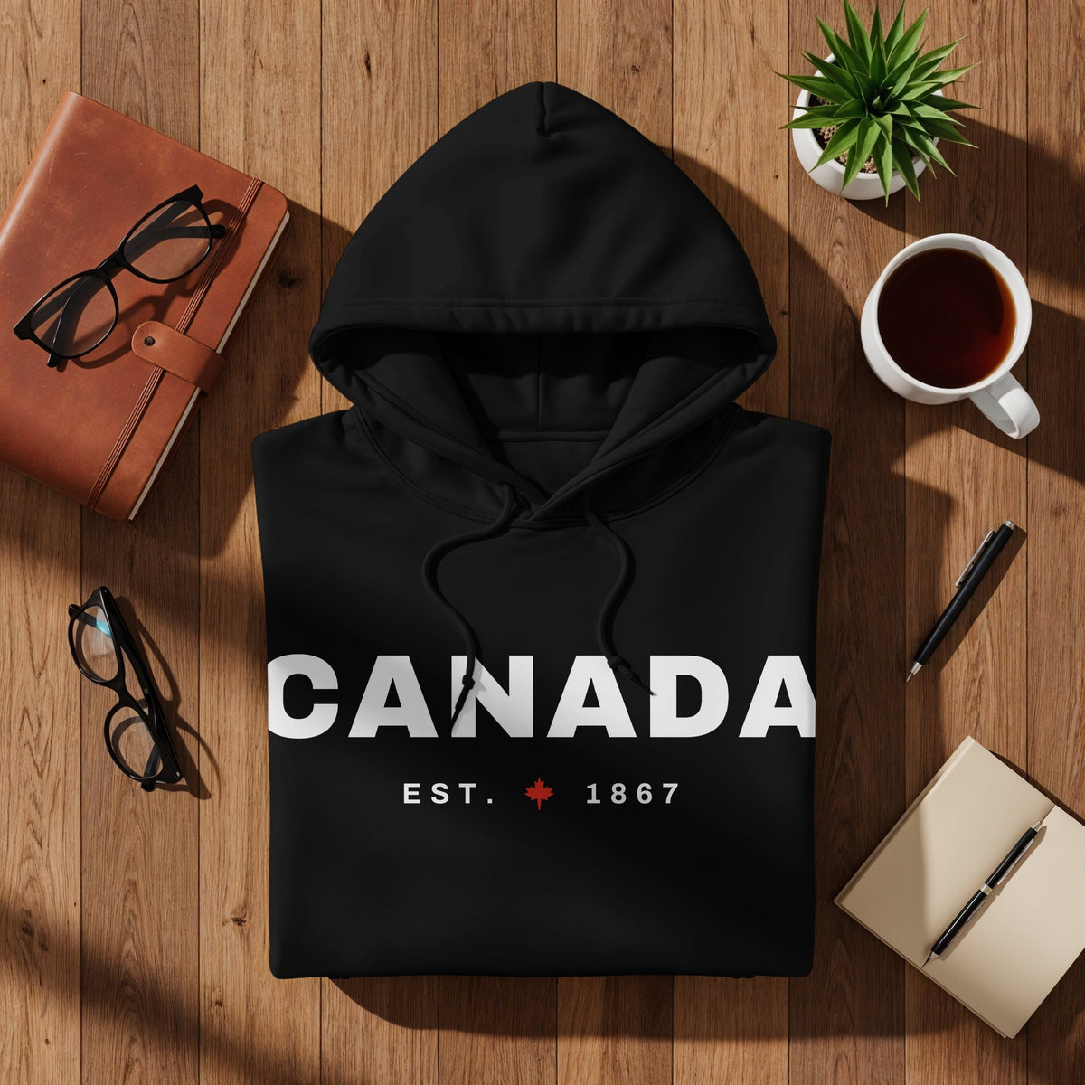Black hoodie with "CANADA EST. 1867" text and a Canadian maple leaf.