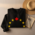 Black sweatshirt with a red maple leaf and yellow stars graphic.