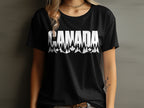 Black t-shirt with white text "CANADA" over a forest and maple leaf design.