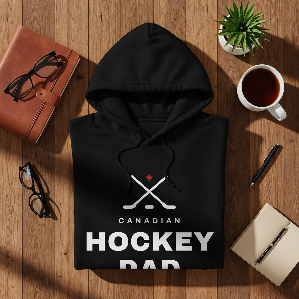 Black hoodie with "Canadian Hockey Dad" text and crossed hockey sticks graphic.