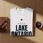 White t-shirt with red maple leaf and text "STILL LAKE ONTARIO"