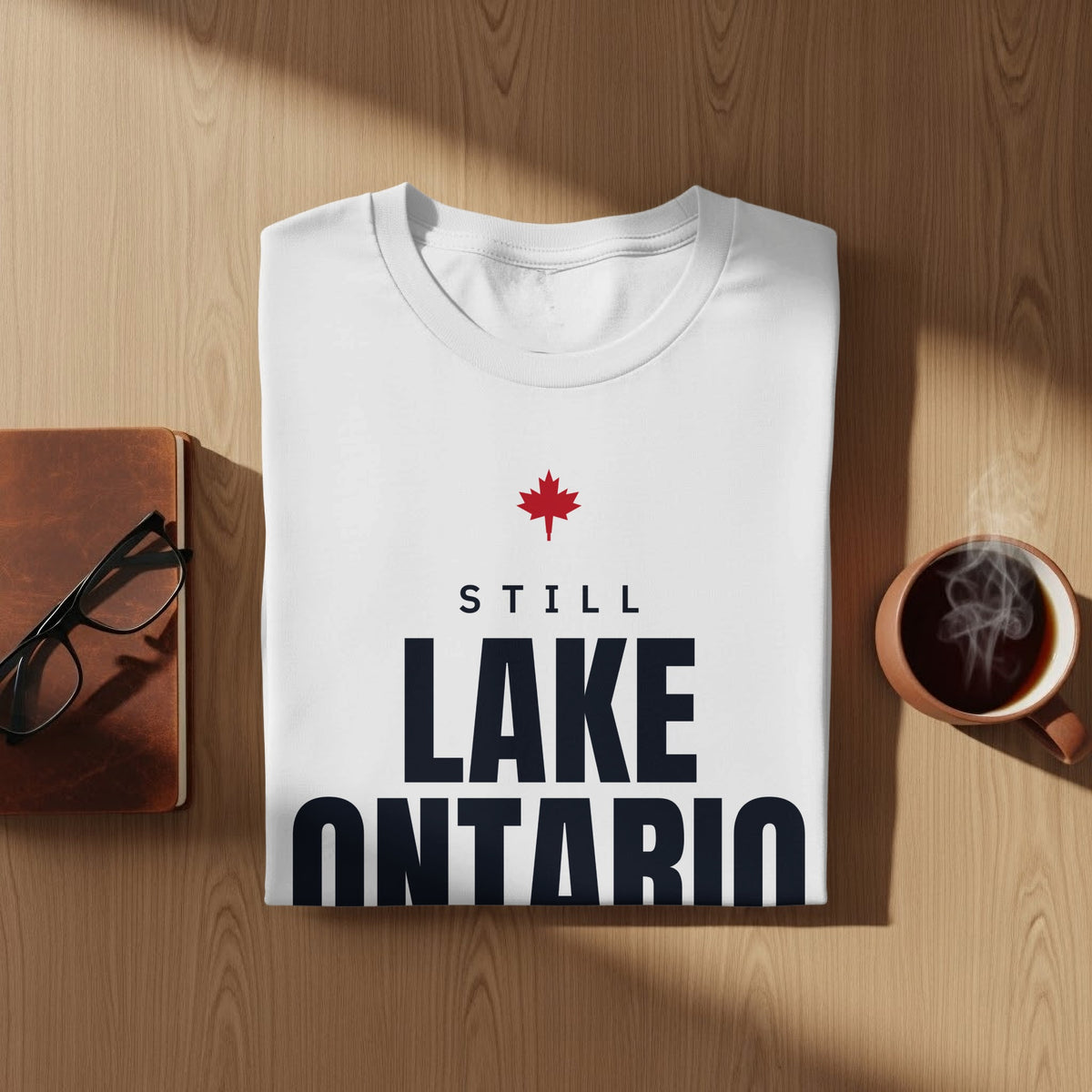 White t-shirt with red maple leaf and text "STILL LAKE ONTARIO"