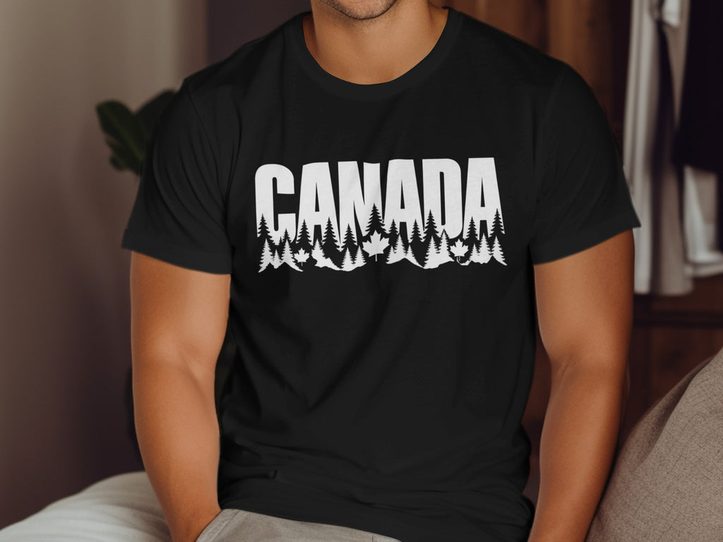 Black t-shirt with white text "CANADA" above a forest and maple leaf design.