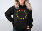 Black hoodie with a circle of yellow stars and a red maple leaf.