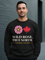 Black sweatshirt with pink rose, red maple leaf, and "WILD ROSE. TRUE NORTH. STRONGER TOGETHER." text.