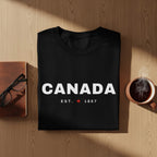 Black t-shirt with white "CANADA EST. 1867" text and maple leaf.