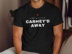Black t-shirt with white text "I GOT A LITTLE CARNEY'D AWAY" and a red maple leaf.