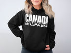 Black hoodie with "CANADA" text featuring trees and maple leaves design